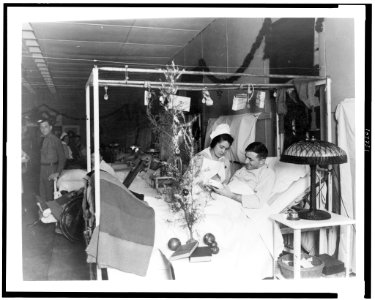 Red Cross nurse alongside of soldier in hospital bed, with Christmas decorations LCCN93505085 photo