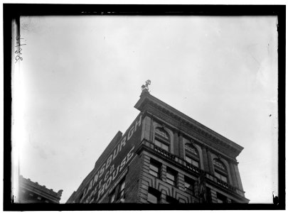 REYNOLDS, J., PERFORMING ACROBATIC AND BALANCING ACTS ON HIGH CORNICE ABOVE 9TH STREET, N.W. LCCN2016868358 photo