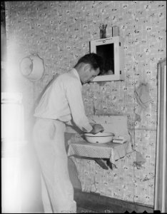 Richard Hughes, a miner, washes his hands in the kitchen of his four room house for which he pays $9 monthly. Panther... - NARA - 540996
