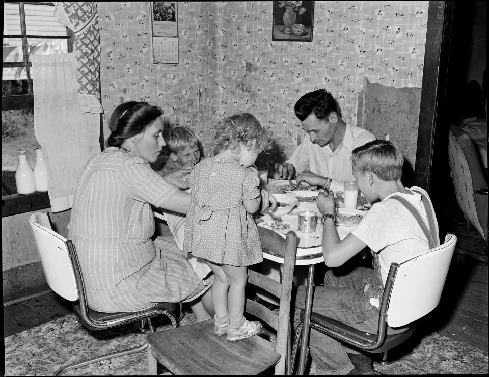 Richard Hughes, miner, and his family eating. This family lives in a four room house for which they pay $9 monthly.... - NARA - 540990