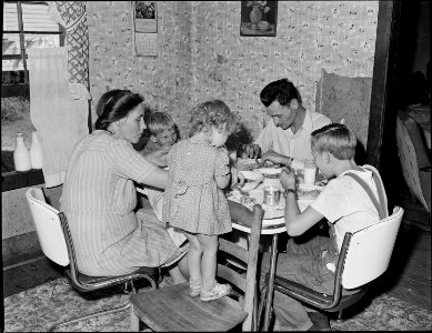 Richard Hughes, miner, and his family eating. This family lives in a four room house for which they pay $9 monthly.... - NARA - 540990