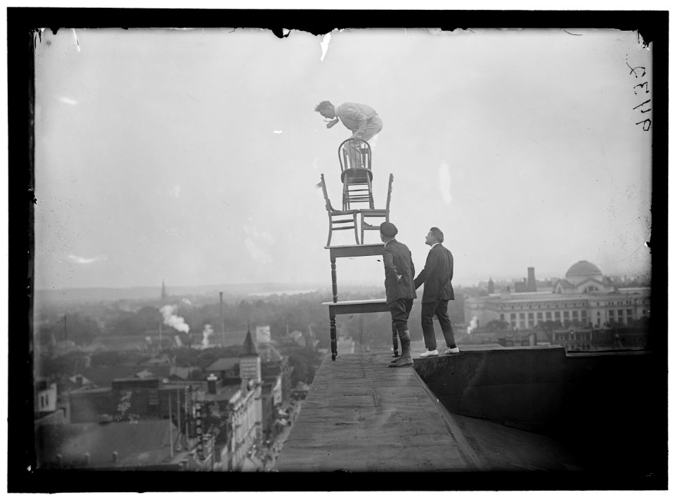 REYNOLDS, J., PERFORMING ACROBATIC AND BALANCING ACTS ON HIGH CORNICE ABOVE 9TH STREET, N.W. LCCN2016868362 photo
