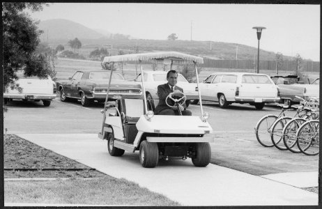 Richard M. Nixon driving a golf cart out to the helipad at San Clemente. - NARA - 194652 photo