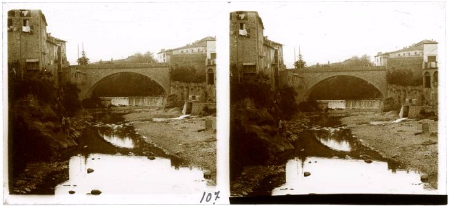Riu passant per sota un pont amb cases a ambdós costats