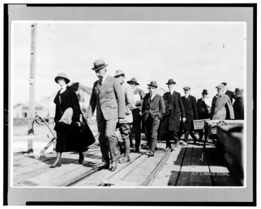 Roald Amundsen, full-length portrait, facing left, walking on pier, with group of people LCCN98515899