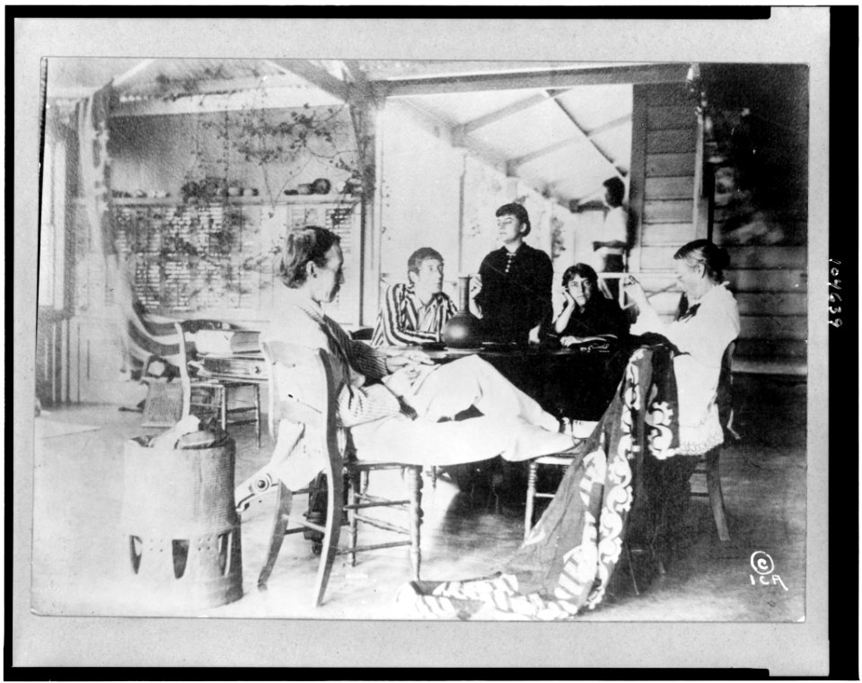 Robert Louis Stevenson with his family sitting around table at home in the Hawaiian Islands LCCN92504557