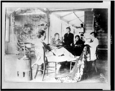 Robert Louis Stevenson with his family sitting around table at home in the Hawaiian Islands LCCN92504557