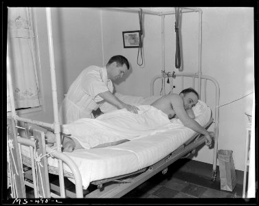 Roger DiGiacomo, miner, being examined for back injury which he received in his work. He is a patient in company... - NARA - 540449