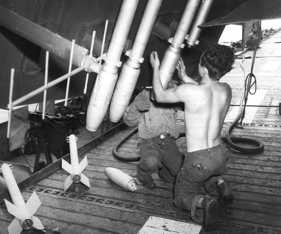 Rockets being loaded onto a TBM-3 Avenger torpedo bomber in support of the Battle of Okinawa onboard the USS Shamrock Bay (CVE-84)