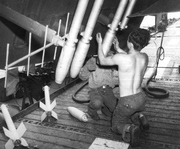 Rockets being loaded onto a TBM-3 Avenger torpedo bomber in support of the Battle of Okinawa onboard the USS Shamrock Bay (CVE-84)