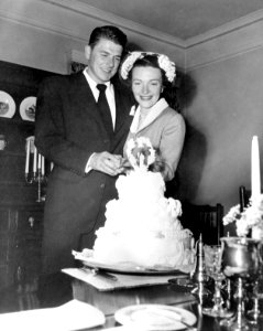 Ronald Reagan and Nancy Reagan cutting cake at William Holden's house after their wedding in Toluca Lake, California photo