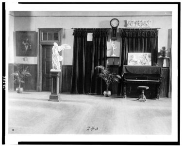 Room with piano, potted palms, and classical statues and friezes LCCN95500448