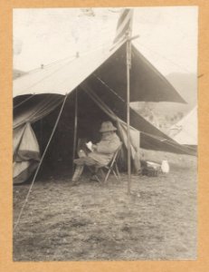 Roosevelt reading in front of his tent in hunting camp LCCN2010645482