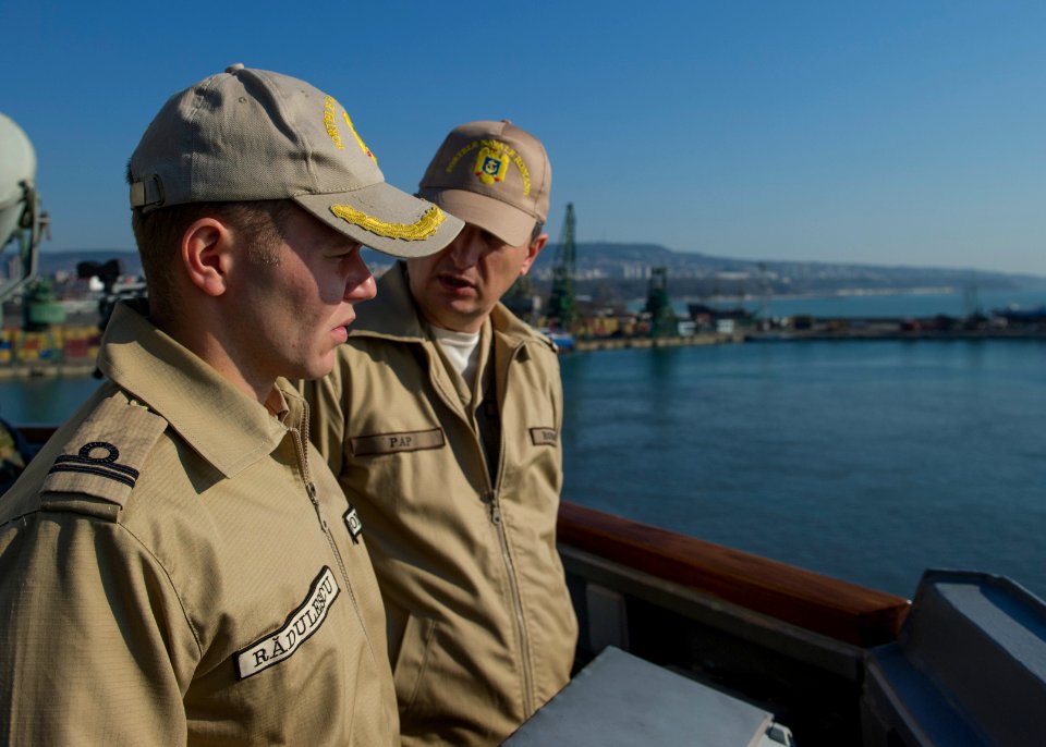 Romanian Naval Forces Lt. j.g. Radu Radulescu, left, and Chief Warrant Officer Daniel Andrei Pap watch from the guided missile destroyer USS Truxtun (DDG 103) as the ship pulls into Varna, Bulgaria, March 13 140313-N-EI510-116