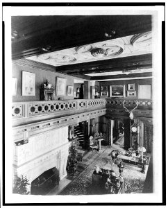 Room with balcony, paintings, fireplace, grandfather clock, and elk head, in home of Edmund Cogswell Converse, Greenwich, Connecticut LCCN94502501