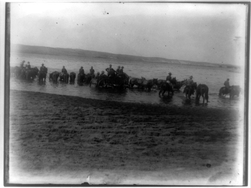 Rough riders on horseback in water with wagon at Montauk Point LCCN96503325