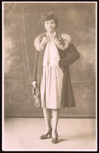 Roxanna Cogburn Davis, hand on hip, wearing fur collard coat and hat, full-length studio portrait, facing front LCCN2015650012