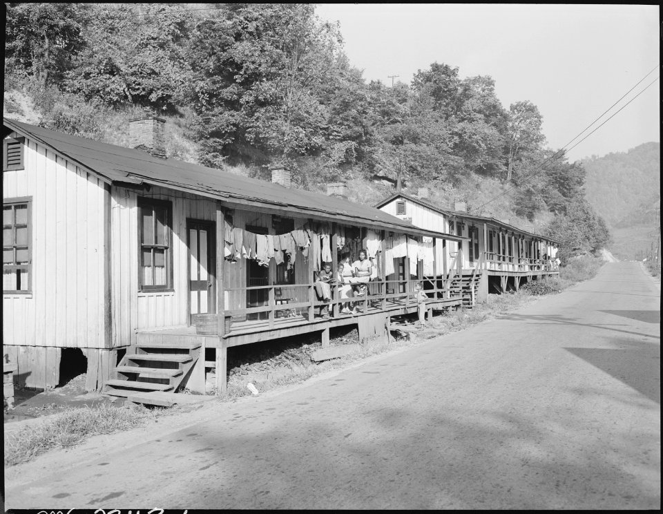 Row of houses, occupied by miners. Where the people are on the porch is the home of Furman Currington. He has 6 rooms... - NARA - 541258