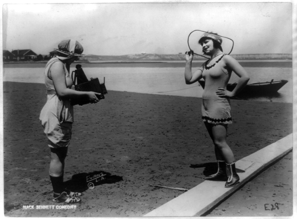 Roxy McGowan and Mary Thurman in bathing suits, with one taking the other's picture on beach, posed for Mack Sennett Productions (3b43826)