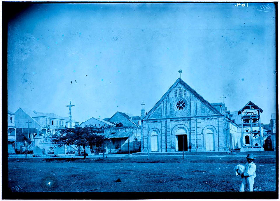 Ruimte met kerk, staande crucifix en bebouwing in Les Cayes op Haïti