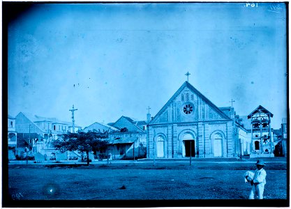 Ruimte met kerk, staande crucifix en bebouwing in Les Cayes op Haïti