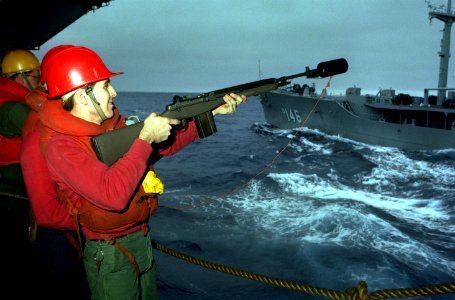 Sailor firing M14 line from CV-63 to USNS Kawishiwi (T-AO-146) 1983