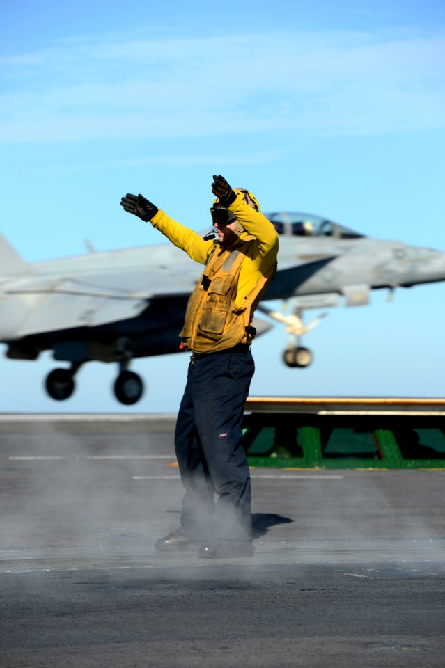 Sailor signals an aircraft during flight operations. (8380447125)