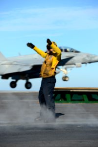 Sailor signals an aircraft during flight operations. (8380447125)