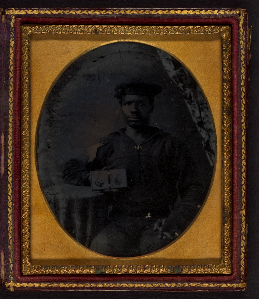 Sailor with cigar in hand holding a double case image of confederate soldiers LCCN2002719391