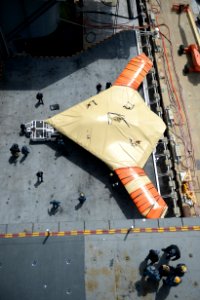 Sailor moves an X-47B from an aircraft elevator aboard USS George H.W. Bush. (8721191680)