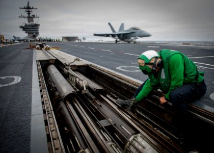 Sailor performs maintenance on a catapult on the flight deck of USS Carl Vinson. (26951190803)