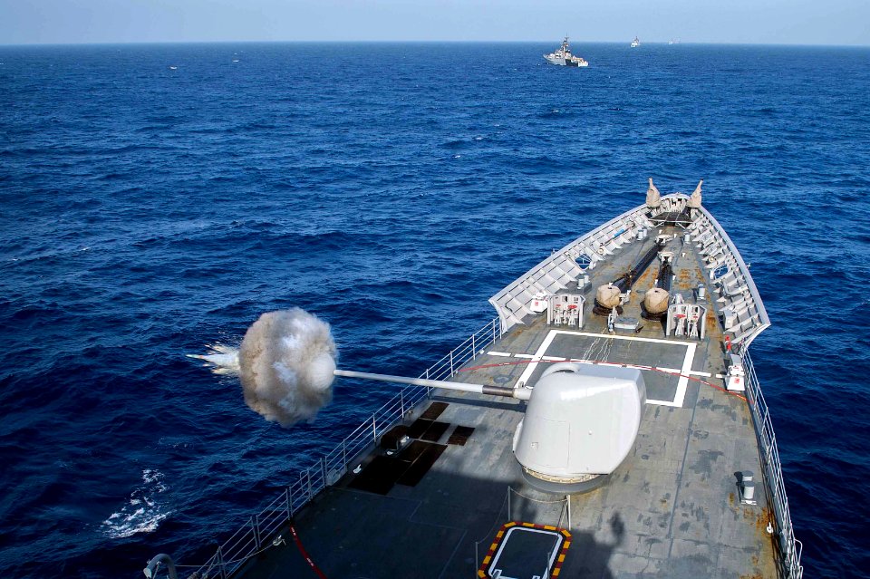 Sailors aboard the guided-missile cruiser USS Mobile Bay (CG 53) fire the Mk-45 5-inch gun during a live-fire surface gun exercise with the INS Kirch (P62), INS Sahyadri (F49) and INS Satpura (F48) during Malabar 2016