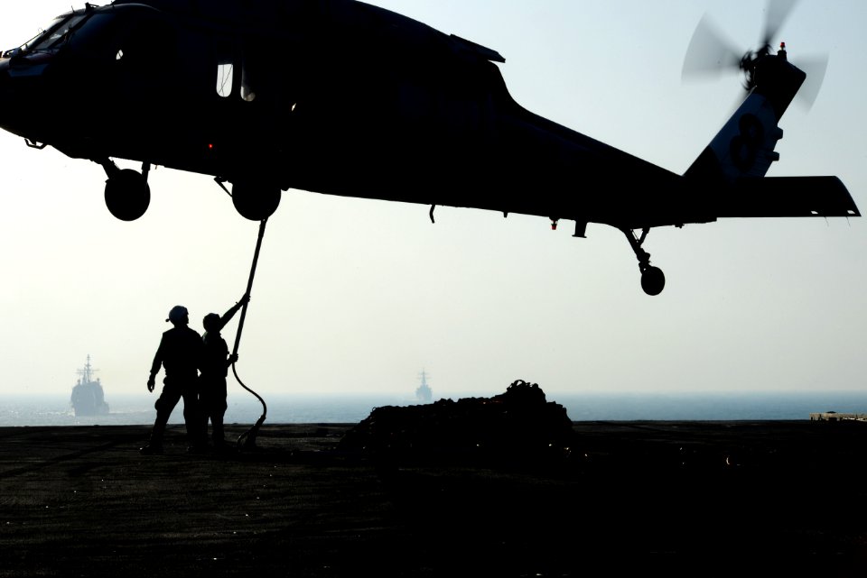 Sailors connect cargo to an MH-60S at sea. (8407486685)