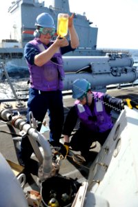 Sailors inspect fuel during a replenishment-at-sea. (8407485673)