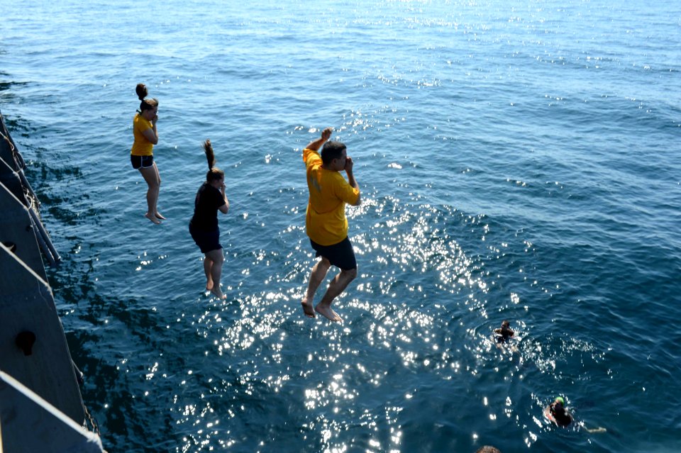 Sailors jump off the ship during swim call. (8202183757)