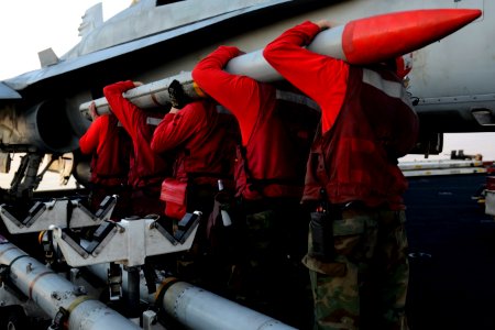 Sailors load a missile onto an F-A-18C at sea. (8498339864)