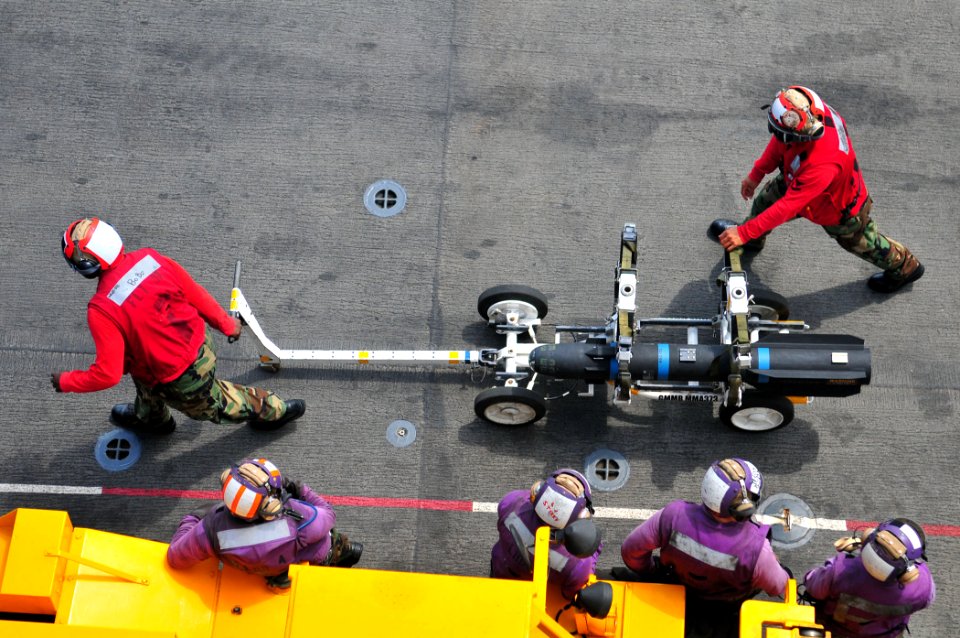 Sailors move a Hellfire Captive Air Training Missile (CATM-114K) across the ship’s flight deck