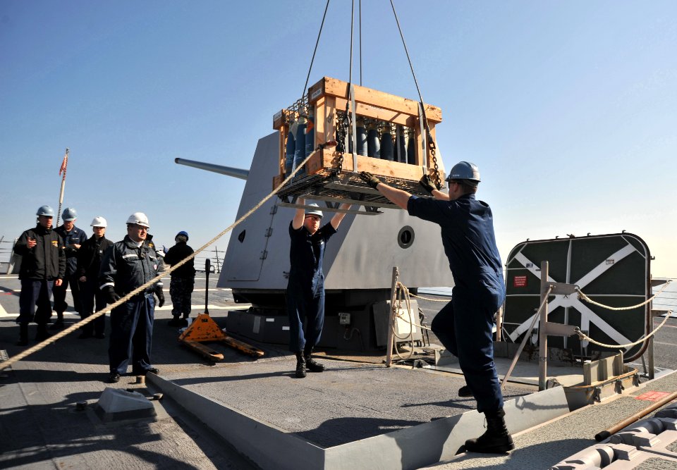 Sailors load ordnance aboard USS Lassen