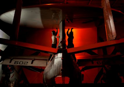 Sailors perform maintenance on the roto-dome gear box on an E-2C Hawkeye