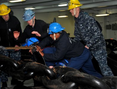 Sailors secure an anchor chain at sea. (8576450685)