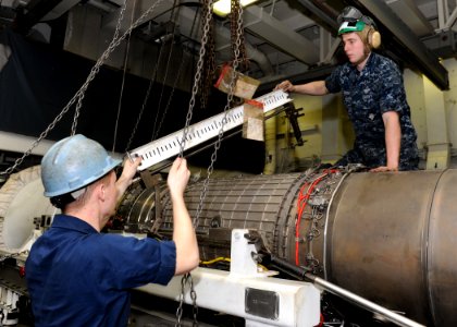 Sailors strap down an engine at sea. (8476433100)
