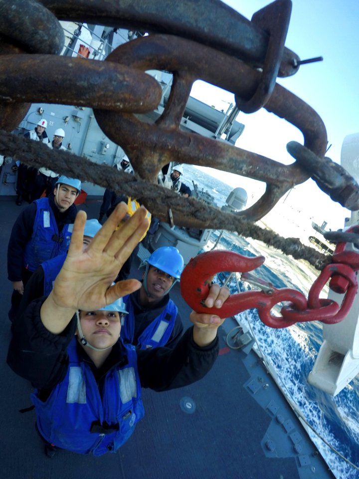 Sailor connecting surf hook during underway replenishment aboard USS Carney (DDG-64) 160207-N-FP878-426