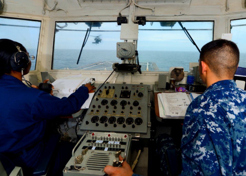 Sailors watch a H-60 as it approaches USS Carter Hall. (8498331000)
