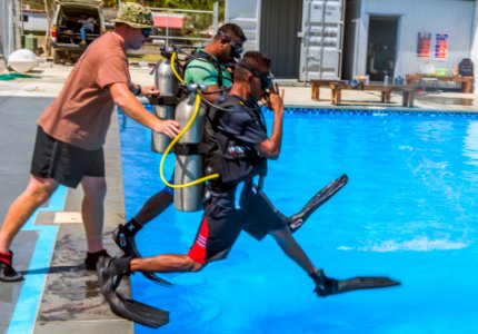 Sailor helps two Timor-Leste sailors enter the water. (35955274280)