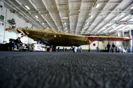 Sailor moves an X-47B into hangar bay aboard USS George H.W. Bush. (8721191994)