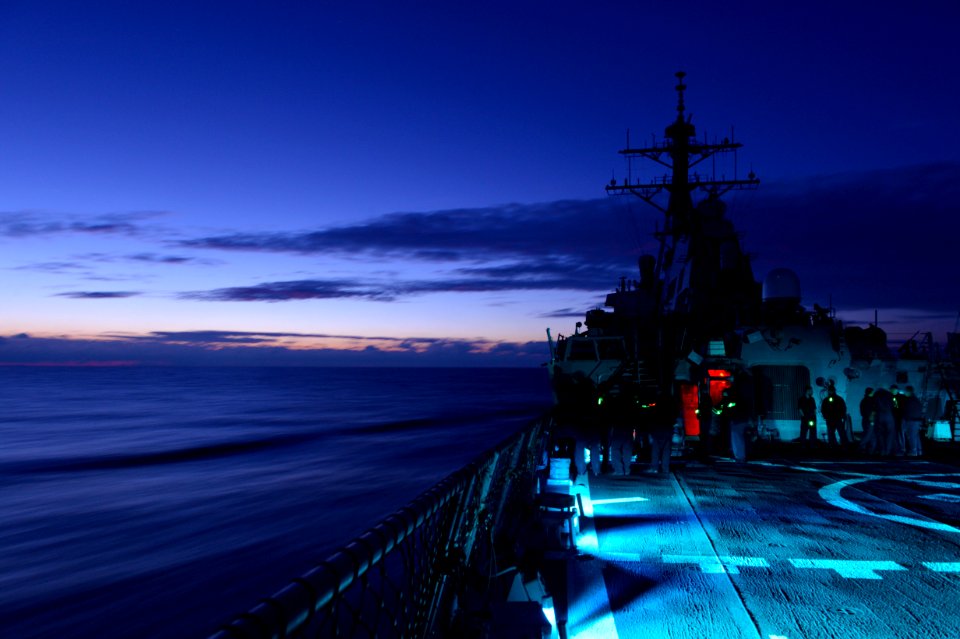 Sailors aboard USS Ross (DDG-71) conducting a low-light gun shoot 151219-N-XT273-076