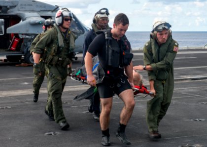 Sailors carry a man aboard USS Carl Vinsonafter completing a rescue-at-sea mission. (18165024510)