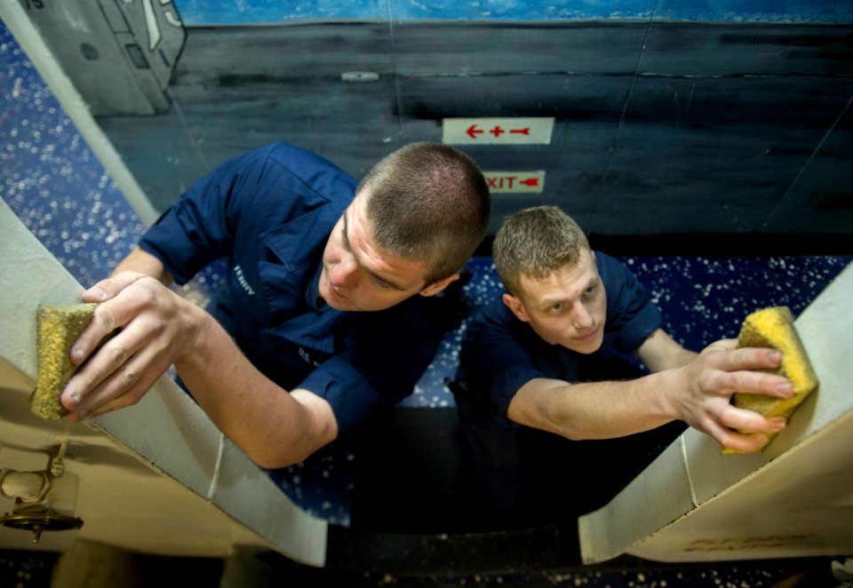 Sailors clean a passageway
