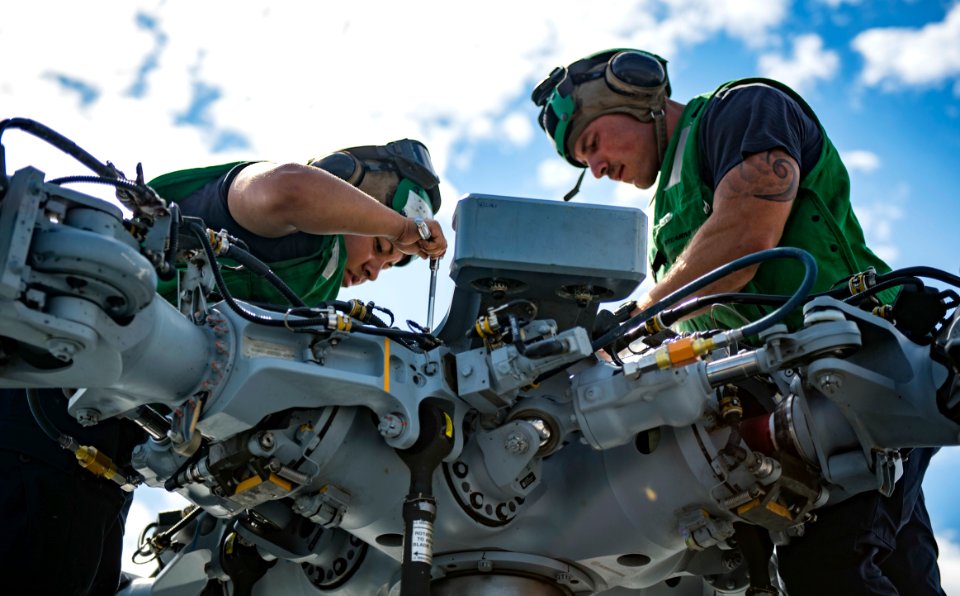 Sailors conduct maintenance on an MH-60S Sea Hawk helicopter on the flight deck of USNS Mercy. (27506356426)