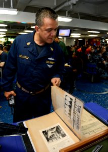 Sailor looks at World War II scrapbook 130604-N-TW634-020